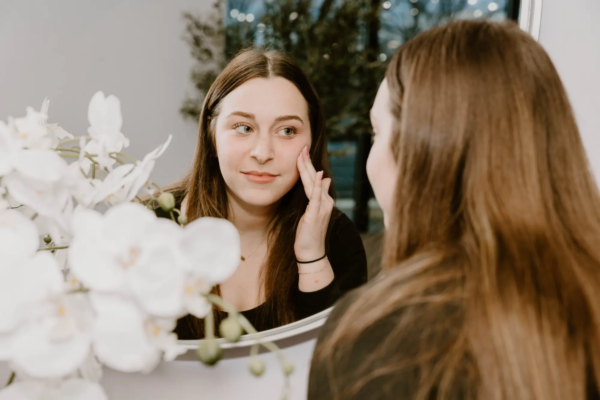 Client at Biltmore Dermatology checking her face after acne treatment